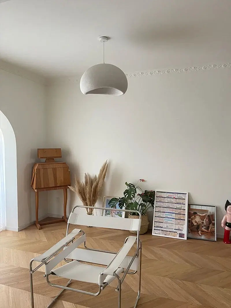 Nordic minimalist pendant light in a modern dining room with stylish furniture and decorative plants.