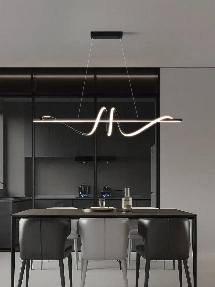 Modern LED pendant light with minimalist design above a dining table in a contemporary kitchen setting.