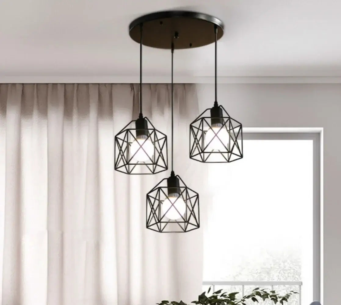 Modern pendant lights with geometric black wire frames illuminating a bright living space. Ideal for dining or bar areas.