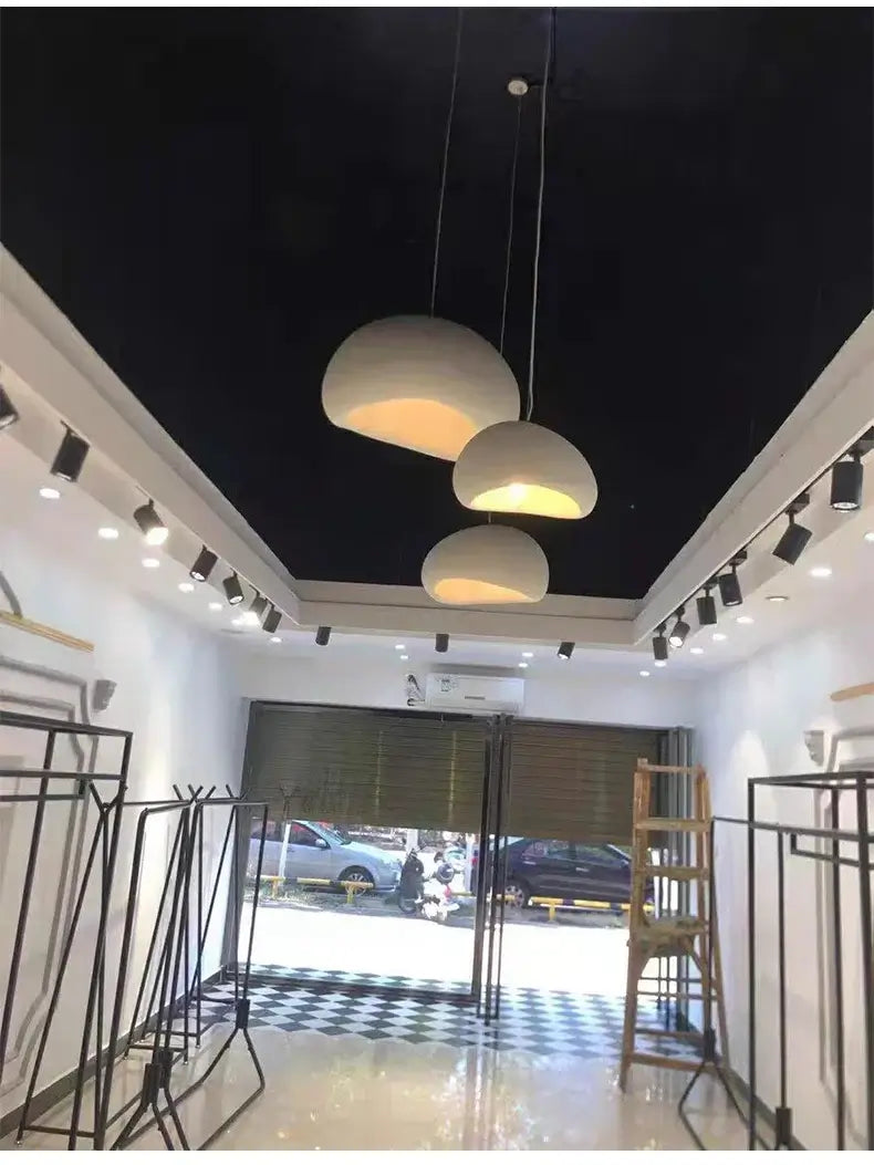 Modern pendant lights in a stylish retail interior with a black ceiling and checkered floor.