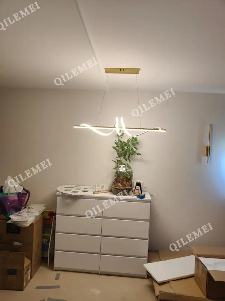 Modern LED pendant light hanging over a minimalist dresser, enhancing home decor in a stylish living space.