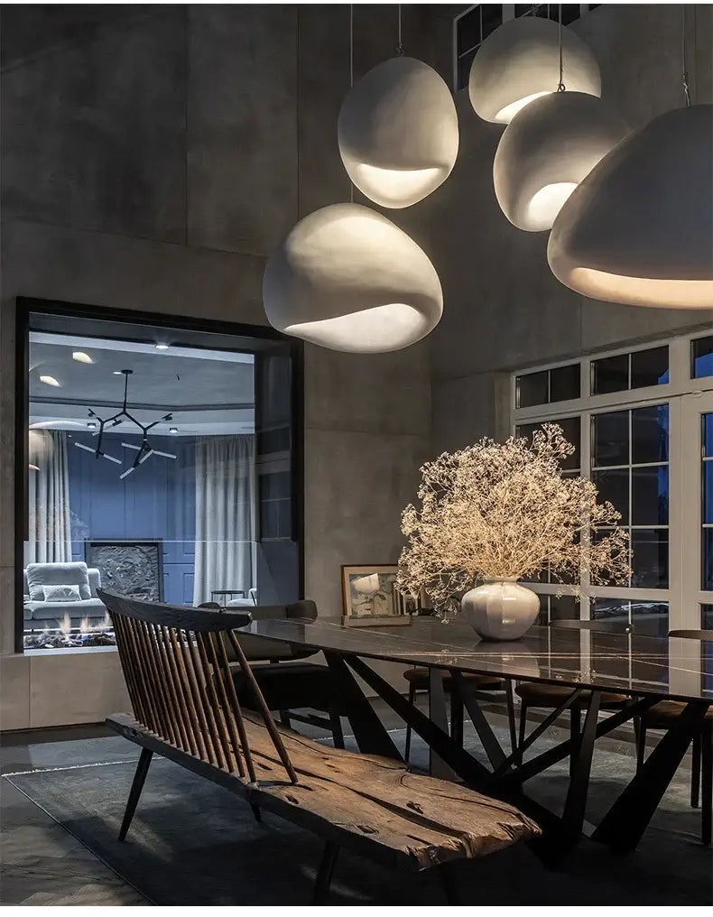 Modern dining room featuring Nordic minimalist pendant lights and a wooden table with decor accents.